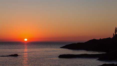 lapso de tiempo del amanecer sobre la orilla rocosa del lago superior