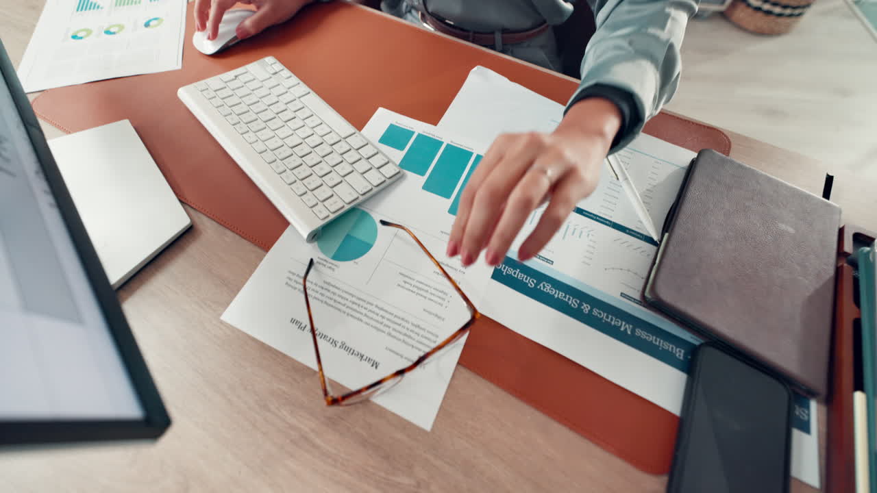 Woman putting on eyeglasses at her desk