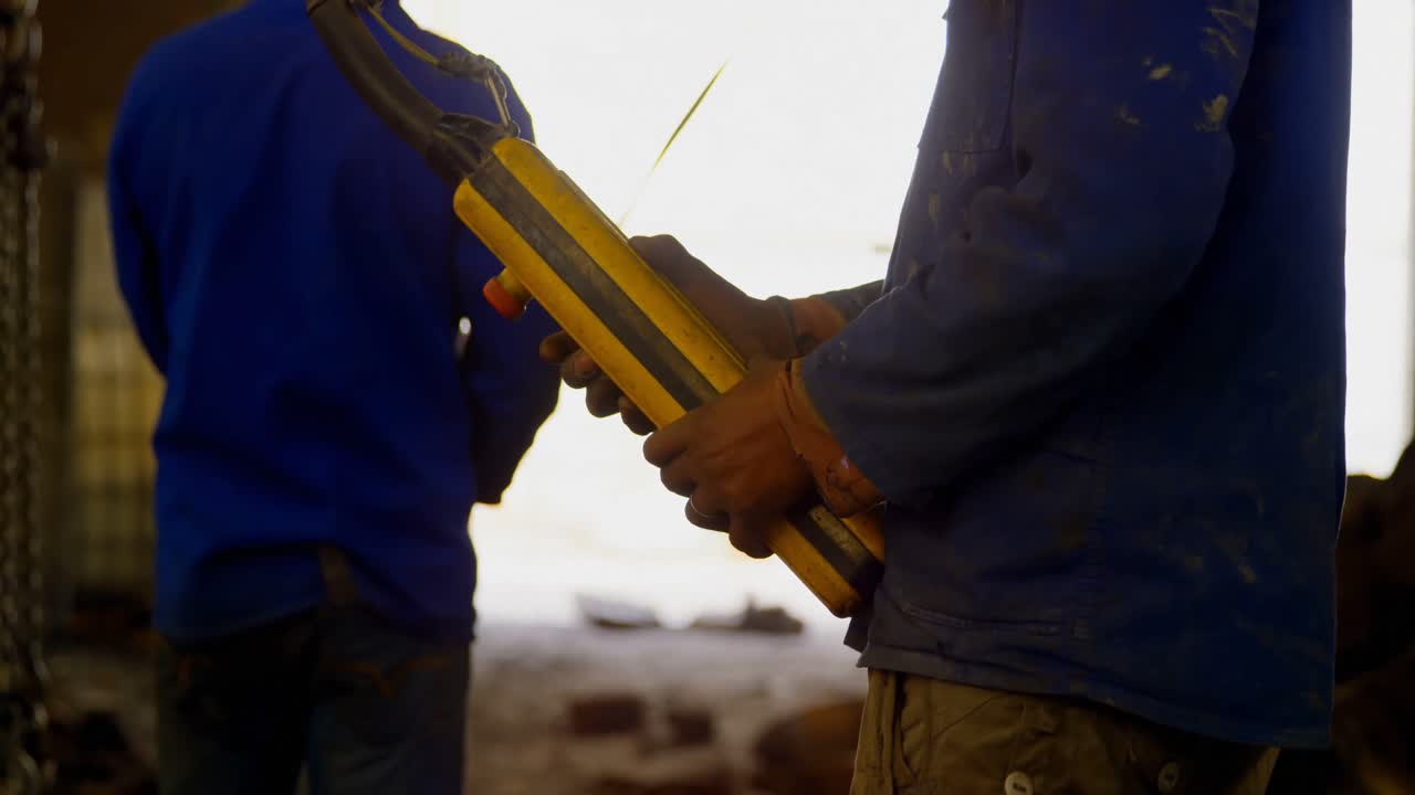trabajador masculino que opera una máquina de grúa aérea en el taller 4k