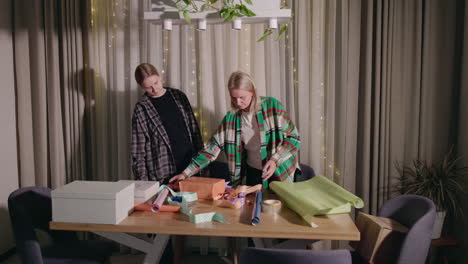 mother and daughter wrapping presents at home