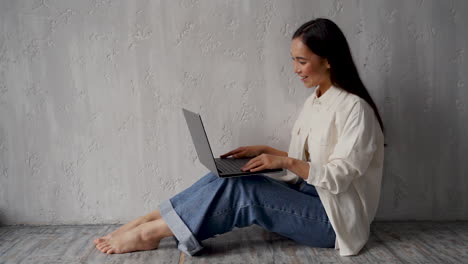 pretty young woman doing online video call, talking to web camera of the laptop, working from home