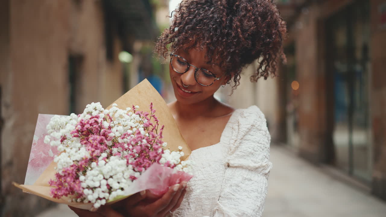 Donna che tiene in mano un bouquet di fiori in una strada cittadina