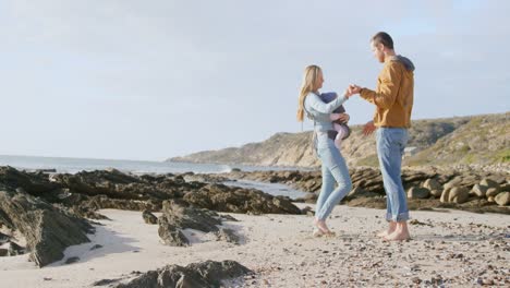 Side-view-of-caucasian-family-dancing-at-beach-on-a-sunny-day-4k