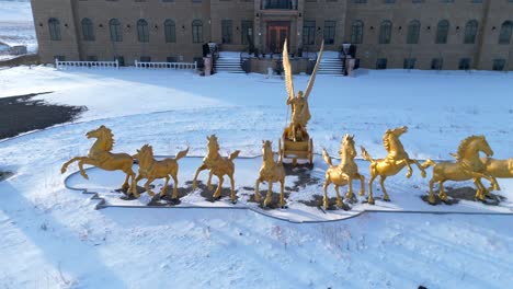 golden statues of horses and a chariot outside a residence in rural alberta