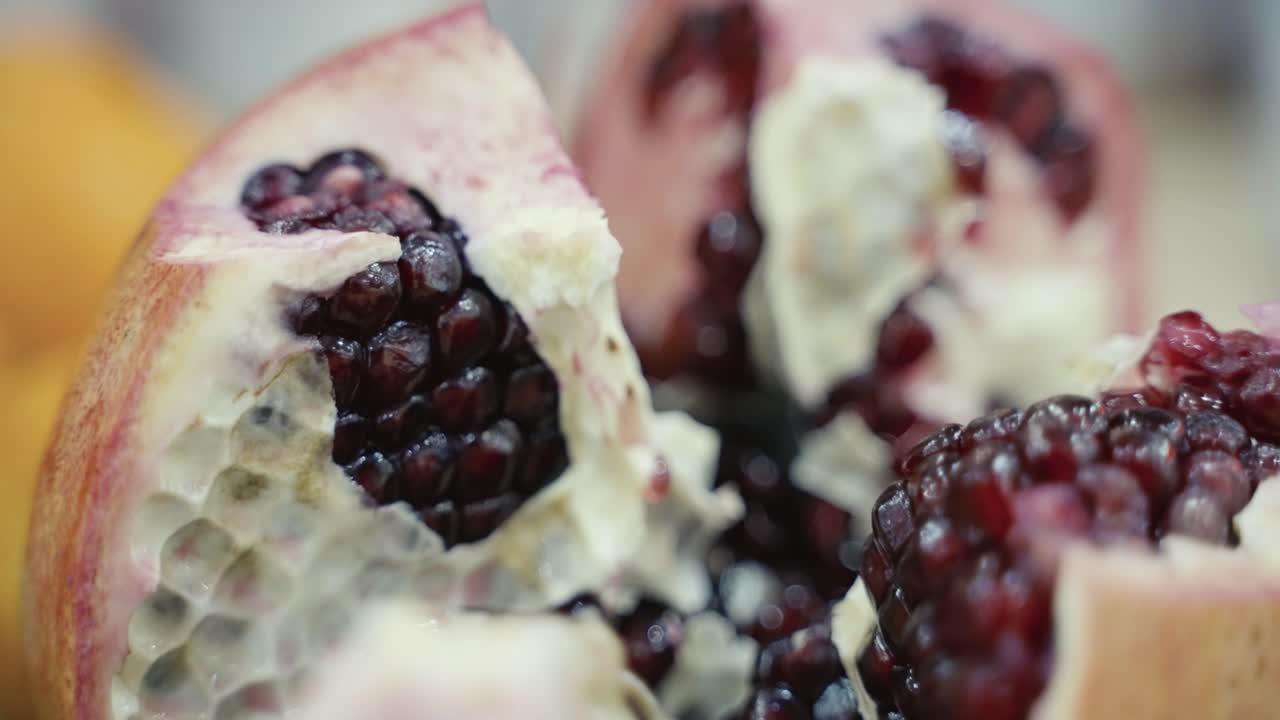Makro-slider-optagelse af et granatæble, der er blevet åbnet for at afsløre frøene indeni.