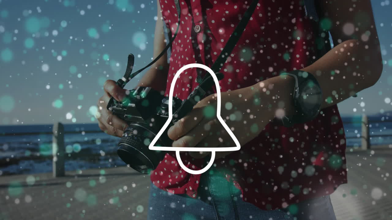 Travel photographer adjusting camera settings on ocean boardwalk, with floating bokeh particles