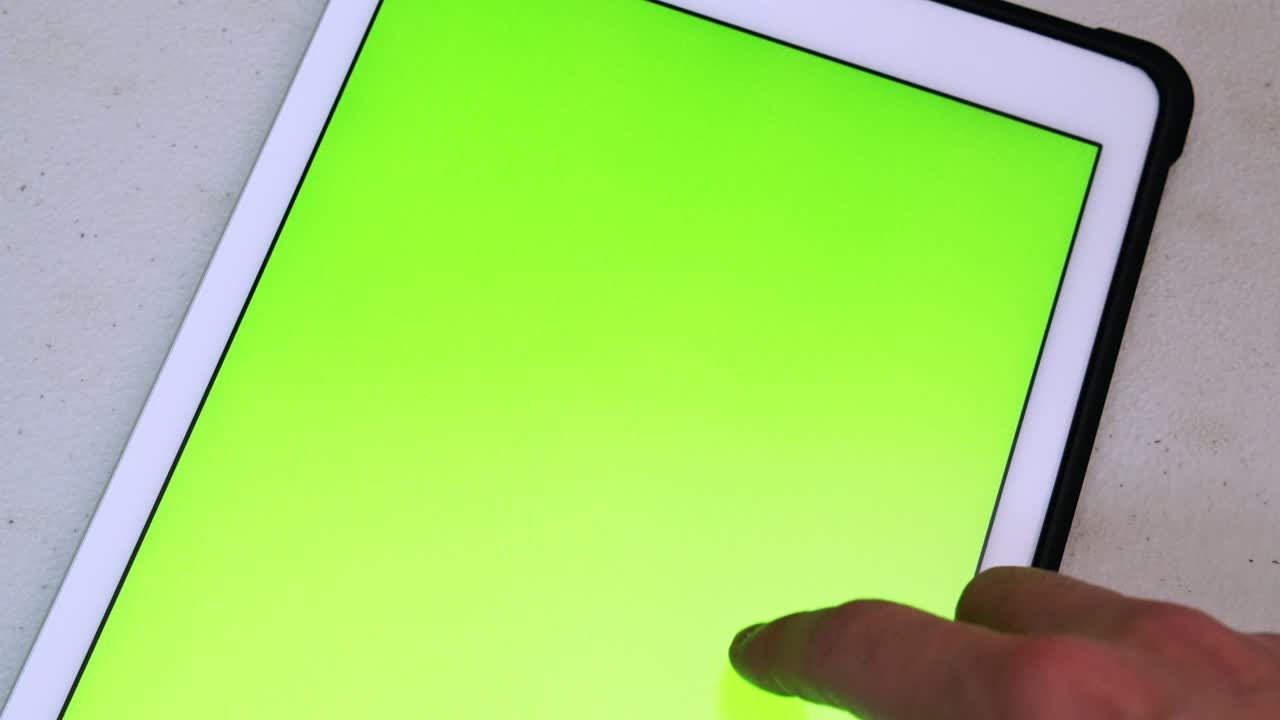 남자가 태블릿의 녹색 화면 웹사이트를 스크롤합니다.