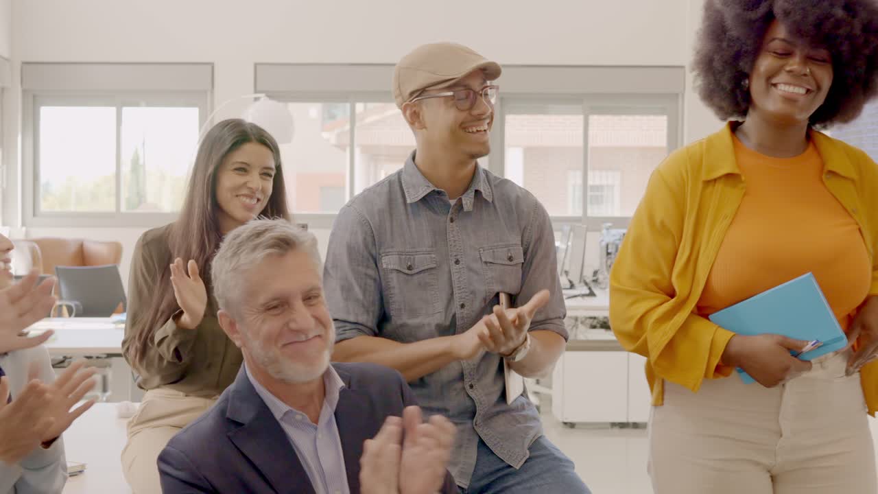 Team congratulating an african colleague in the coworking office