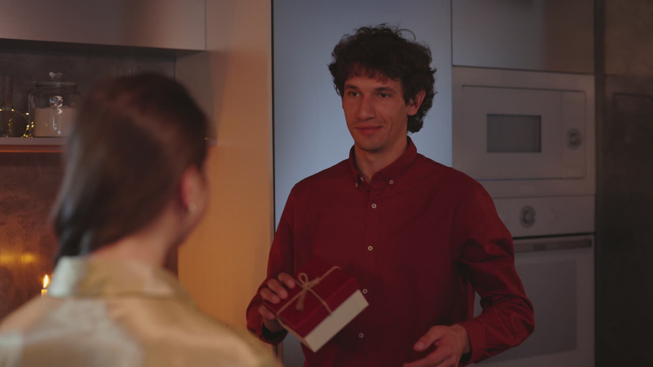 Couple Hugging and Exchanging a Gift