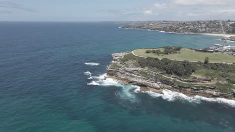 waves crashing at rocky inlet and cliffs of mackenzies point - marks park and coastal walk at peninsula in nsw, australia