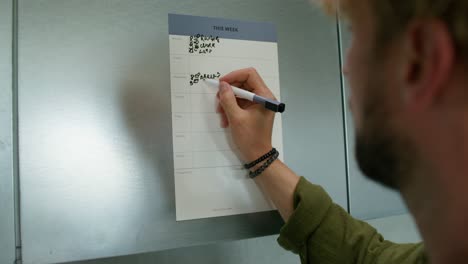 persona que escribe en el planificador semanal