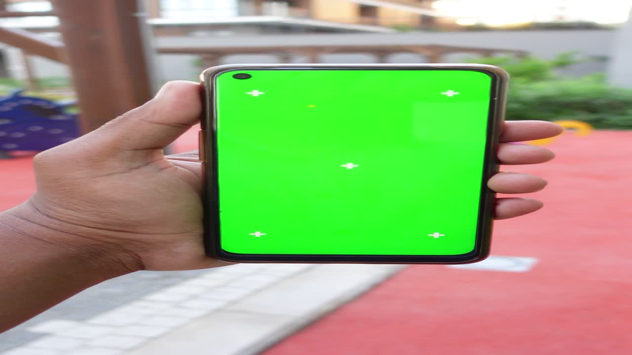 una persona con un teléfono de pantalla verde