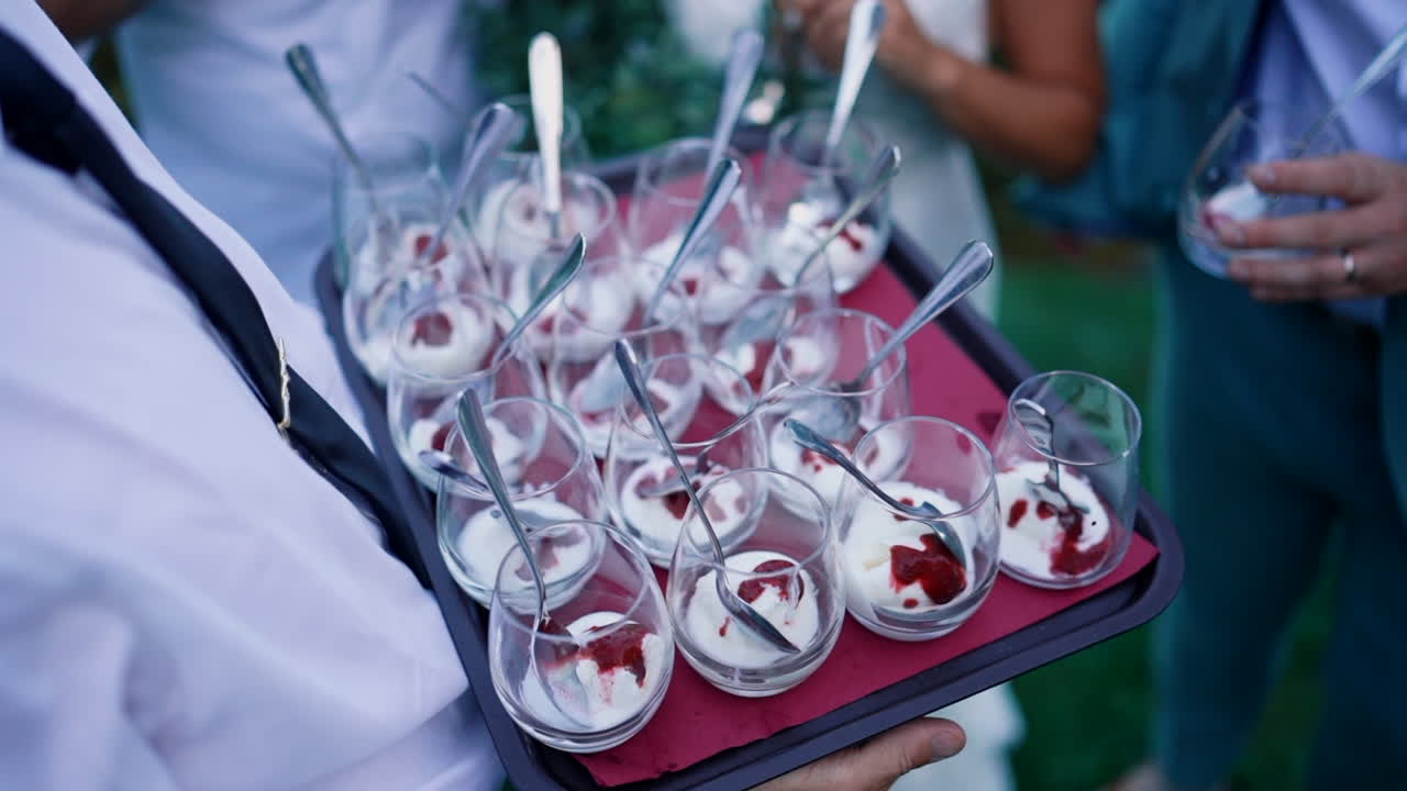 Serveur présentant des coupes de desserts gastronomiques