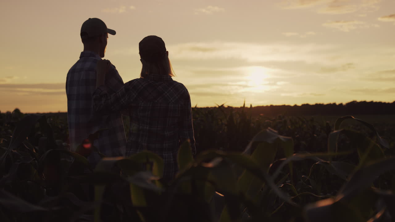 un par de granjeros miran su campo y se abrazan