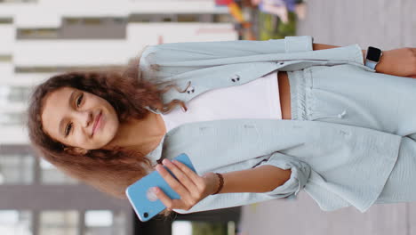 niña preadolescente usa teléfono inteligente escribe mensajes de texto navega por internet termina el trabajo mirando a la cámara
