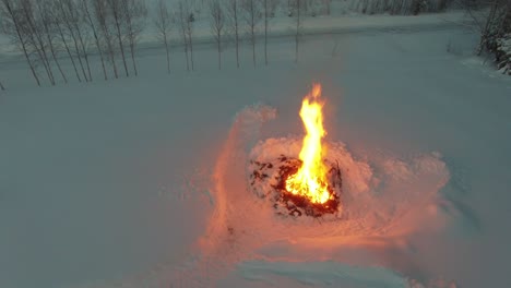 drone flight over big bonfire in winter landscape