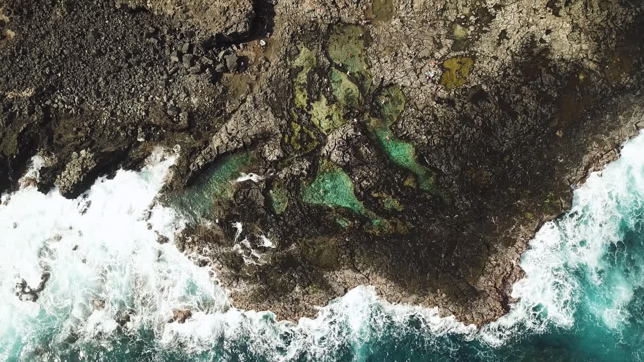 Vista de pájaro de las olas rompiendo en las pozas de marea de Makapu'u, frente a la costa rocosa de Oahu, Hawái