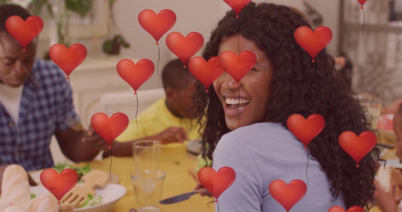 Animazione di palloncini a forma di cuore sopra una famiglia che consuma un pasto insieme al tavolo da pranzo