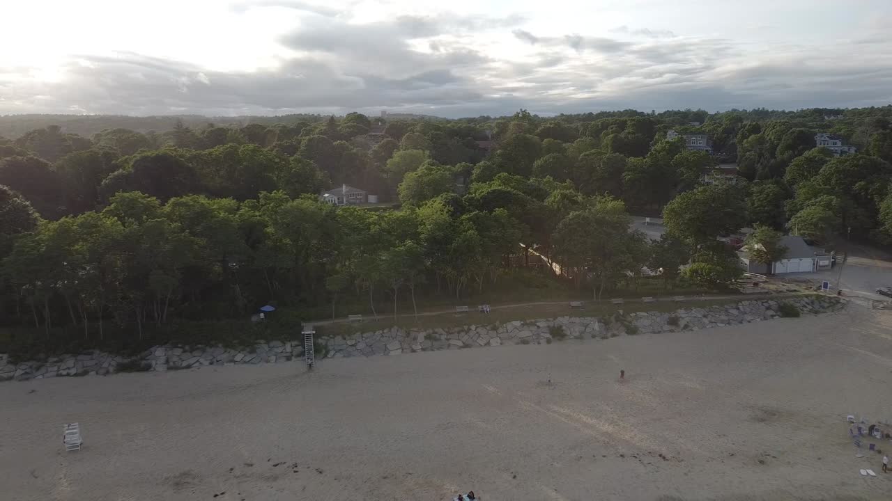 Aerial View of a Sandy Beach with Trees and Houses