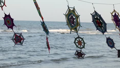 wind spinners gently sway above ocean waves.