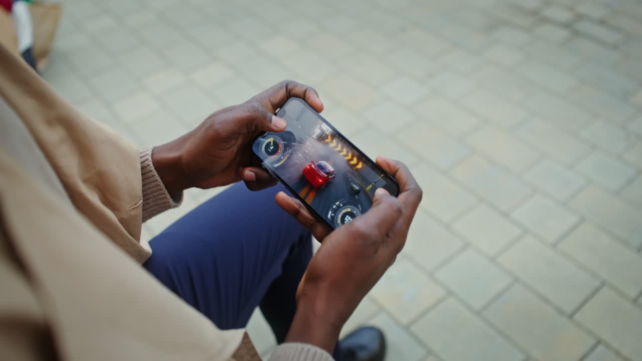 Person playing racing game on phone