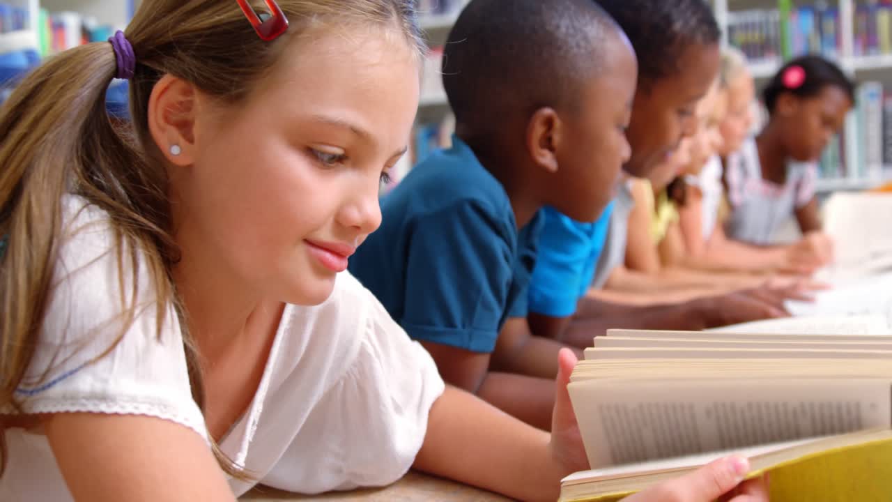 School kids reading book in library