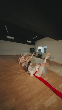 group of women performing contemporary dance with red ribbons