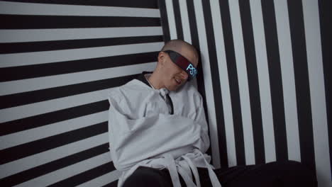bound and disoriented man in futuristic glasses