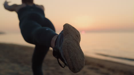mujer fuerte manteniendo el equilibrio de pie con una pierna en la playa. niña practicando yoga.