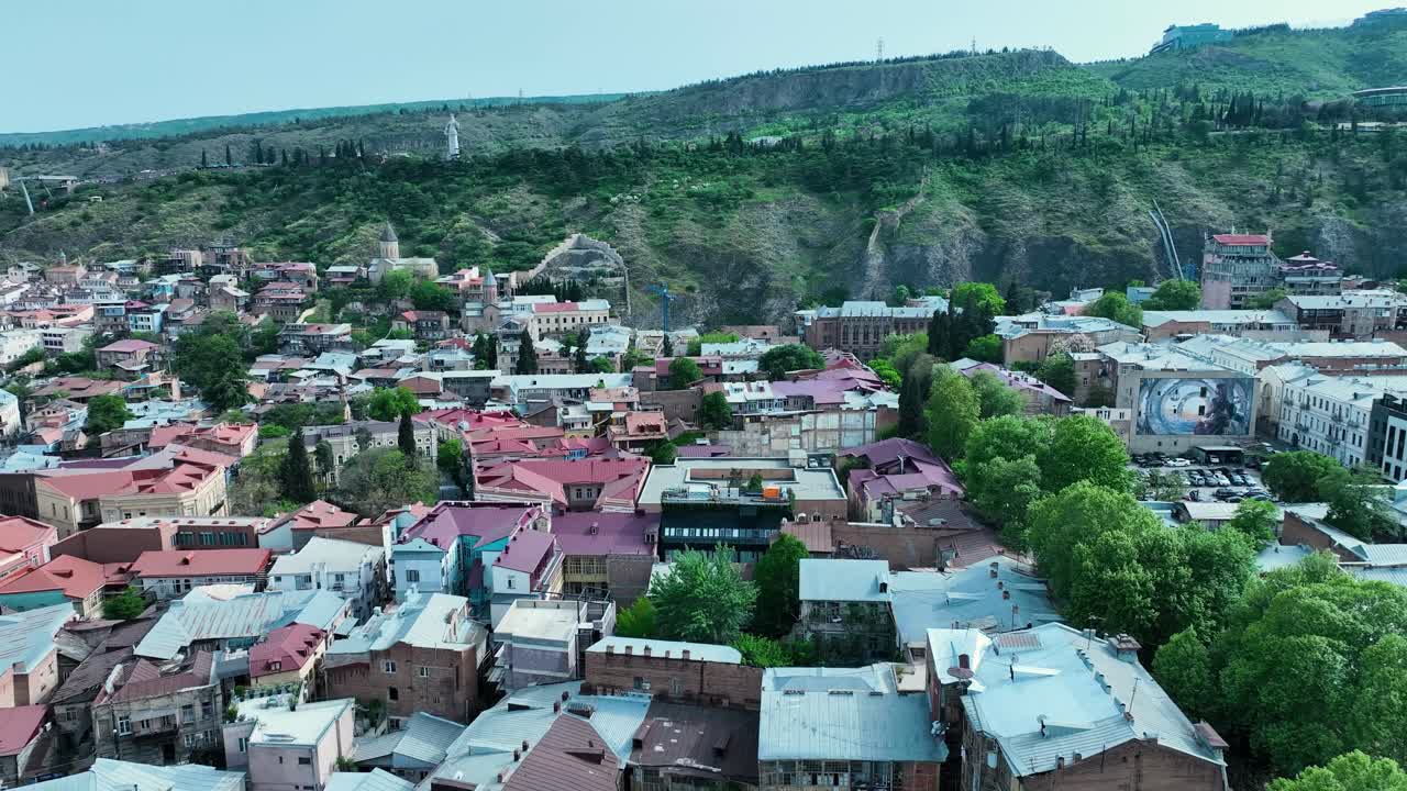 disparo de drones para el paisaje de la antigua tbilisi con edificios antiguos y naturaleza con árboles verdes a principios del verano