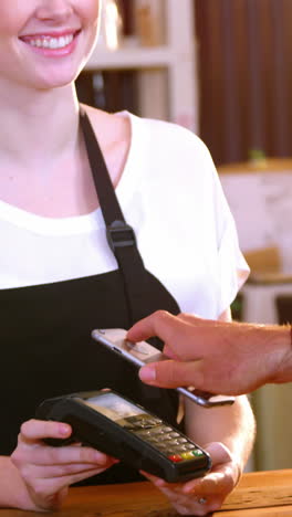 el cliente paga la factura a través de un teléfono inteligente utilizando tecnología nfc