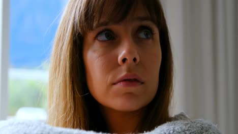 mujer sentada cerca de la ventana en casa 4k
