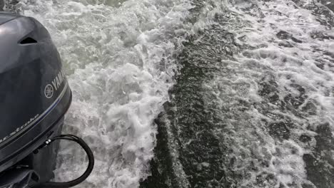 outboard motor generating wake in a body of water