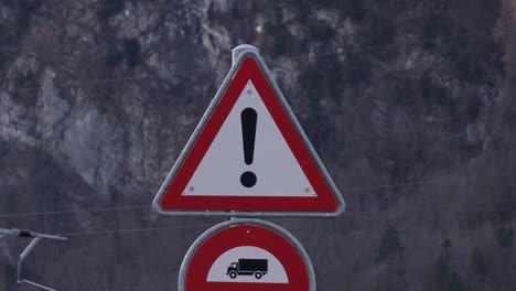 blinking warning sign representing exclamation mark in white triangle, on road side