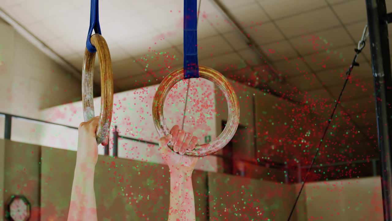 Athlete hands contacting rings, chalk cloud dispersing while adjusting grip for firm hold