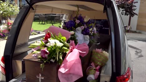 closeup shot of a funeral casket in a hearse or chapel or burial at cemetery