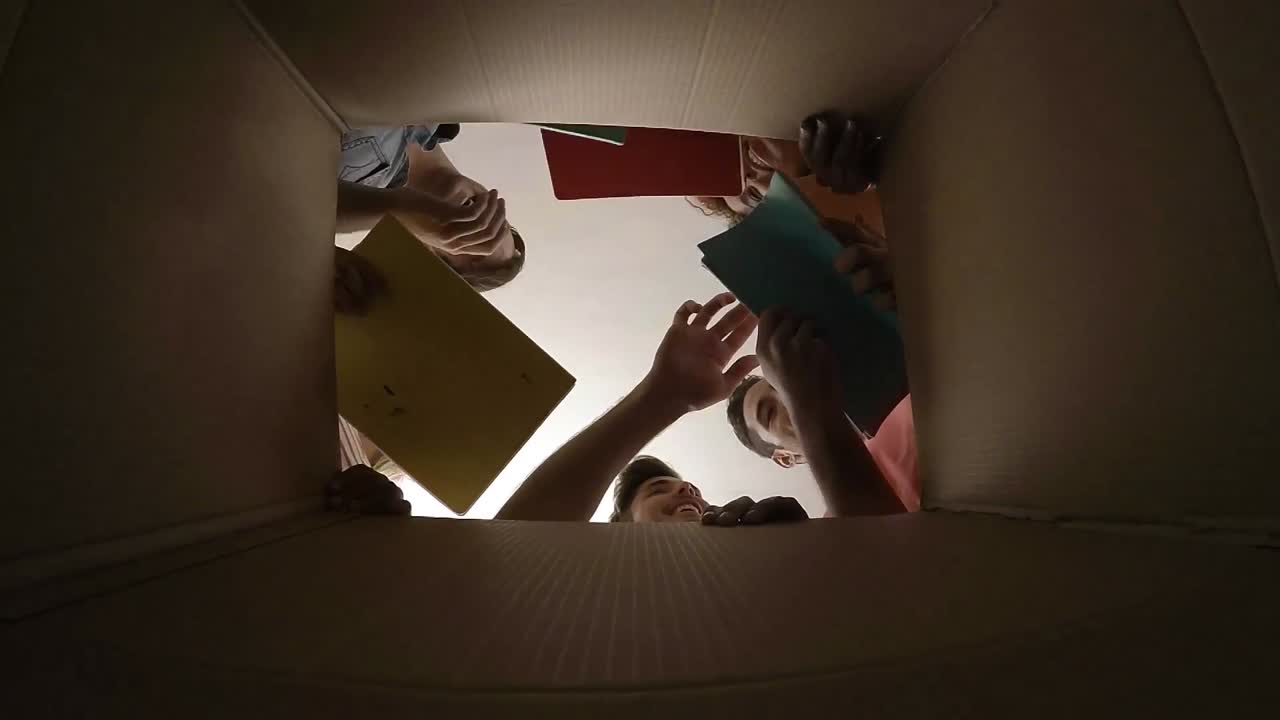 amigos poniendo cuadernos en la caja