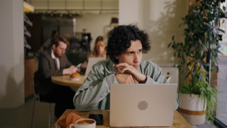 young man working on his laptop in a coffee shop