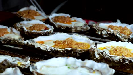 oysters being grilled at a street food stall