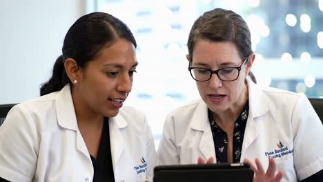 two diverse female doctors collaborating with a digital tablet