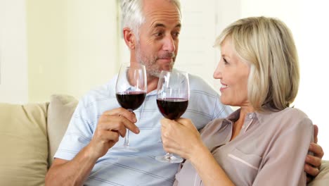 pareja relajándose juntos en el sofá bebiendo vino tinto