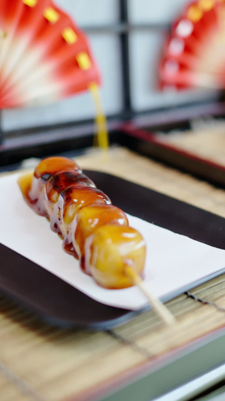 Close up of dango served on a skewer at a street food market in Japan. Vertical