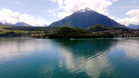 aerial take of the thunensee lake in swiss alps, nearby interlaken town