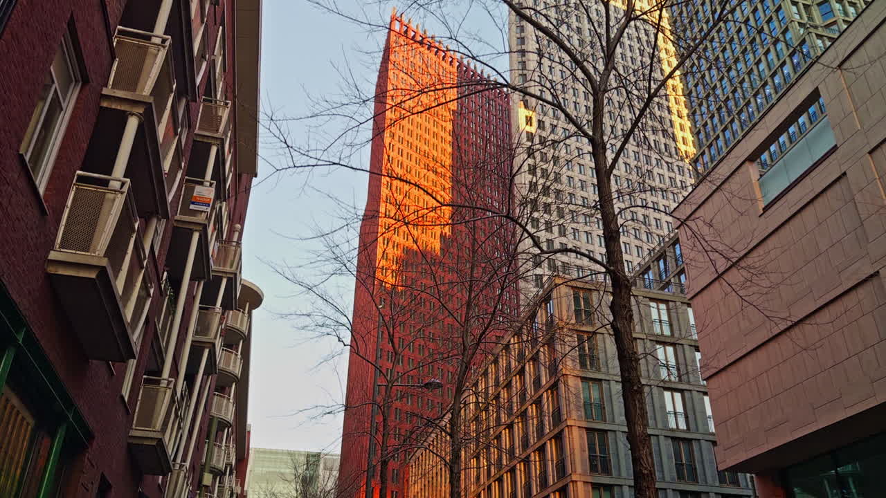 Ciudad urbana moderna europea en los Países Bajos, en La Haya, con edificios y rascacielos durante la hora dorada al anochecer, antes de la puesta de sol, vista de ángulo bajo y amplio