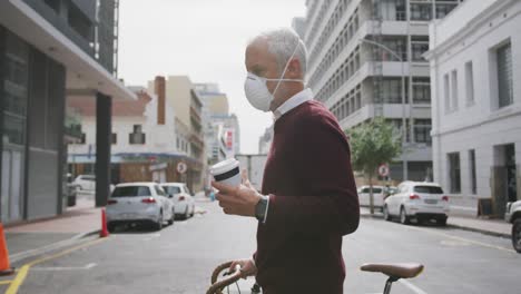 caucasian man out and about in the street wearing on a face mask against coronavirus