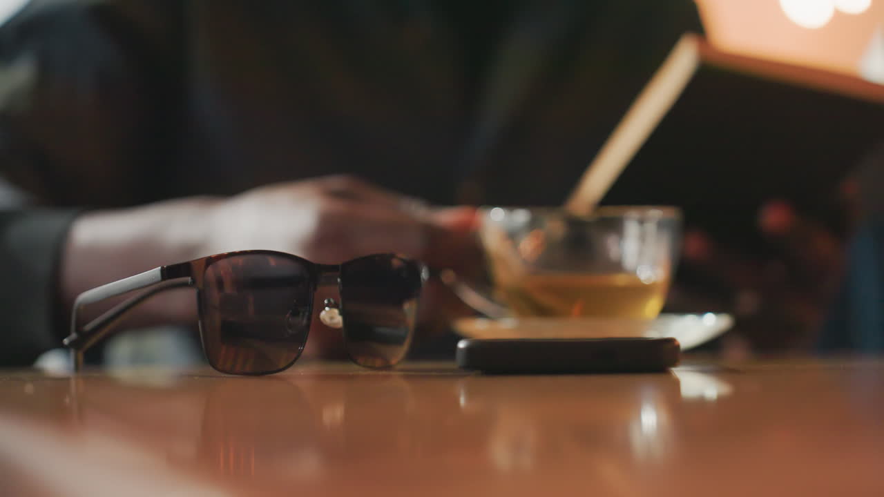 Escritor disfrutando de una lectura tranquila, periodista tomándose un descanso de reflexión con literatura en un ambiente relajante, profesional de los medios disfrutando de momentos introspectivos rodeado de detalles acogedores y ambiente cálido.