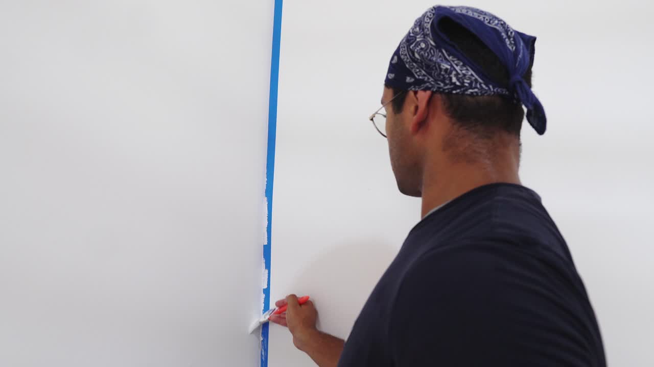 화가 가 벽 가장자리 를 브러쉬 로 칠 하고 있다 - 근접