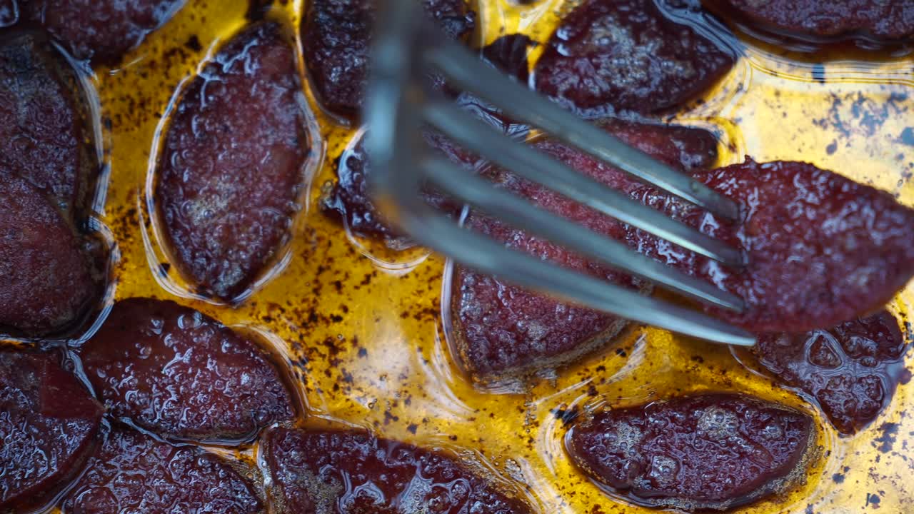 기름 비 에 소시지를 들고 있는 포크 의 클로즈업