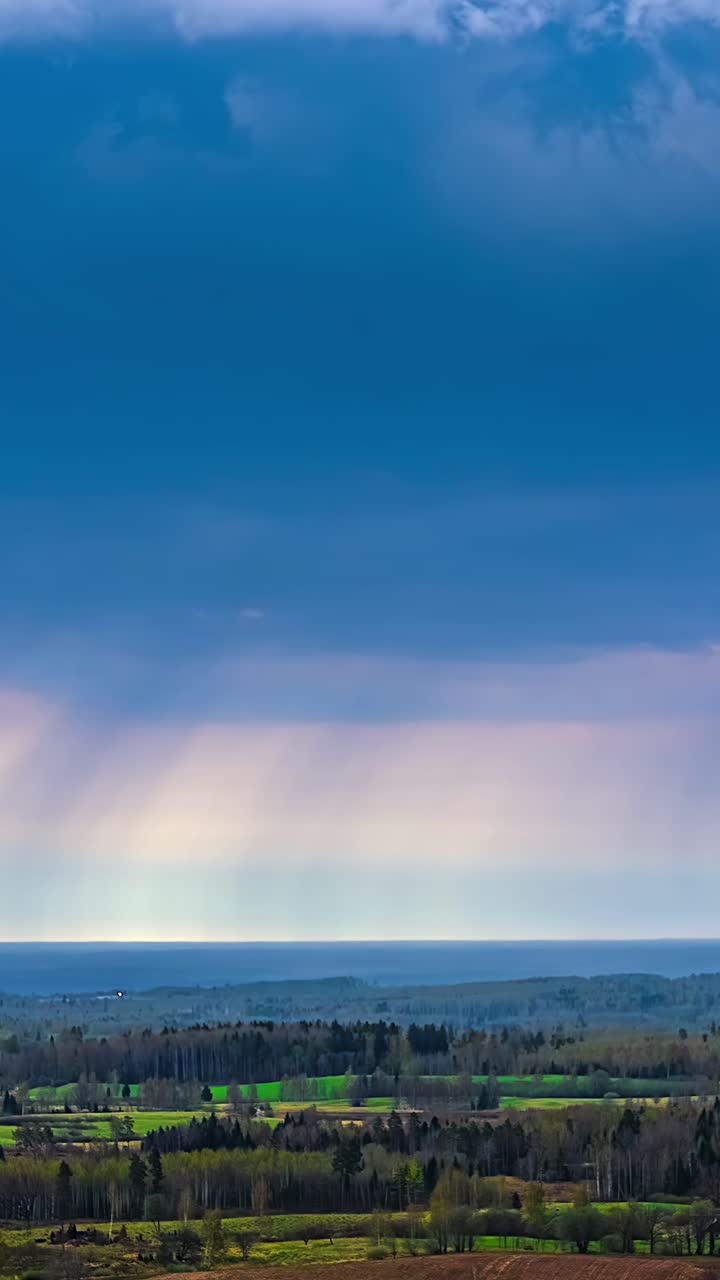 Storm clouds and rain in aerial hyperlapse above countryside, vertical