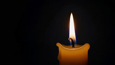 una vela ardiendo en la oscuridad